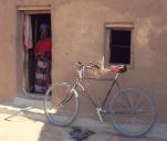 village woman in doorway and bicycle