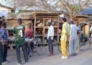 men in market with caged chickens
